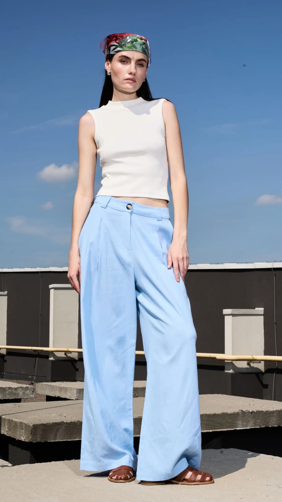 Модель у блакитних лляних штанах з високою посадкою та защипами на даху, повний зріст. (зображення 1 з 4)